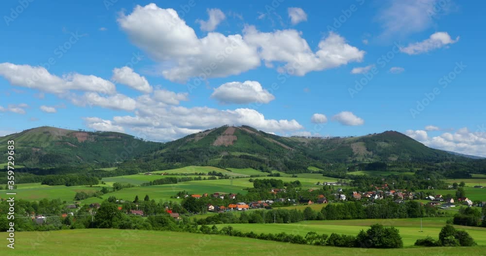 Peaks of hills and mountains lying around the village Kozlovice with a sky full of clouds moving during a sunny day. Peaks of hills and mountains lying around the village Kozlovice with a sky full of clouds moving during a sunny day.