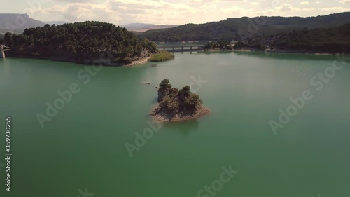 Aerial view orbit right across El Chorro Spanish lake island shimmering sunset mountain valley waterway landscape