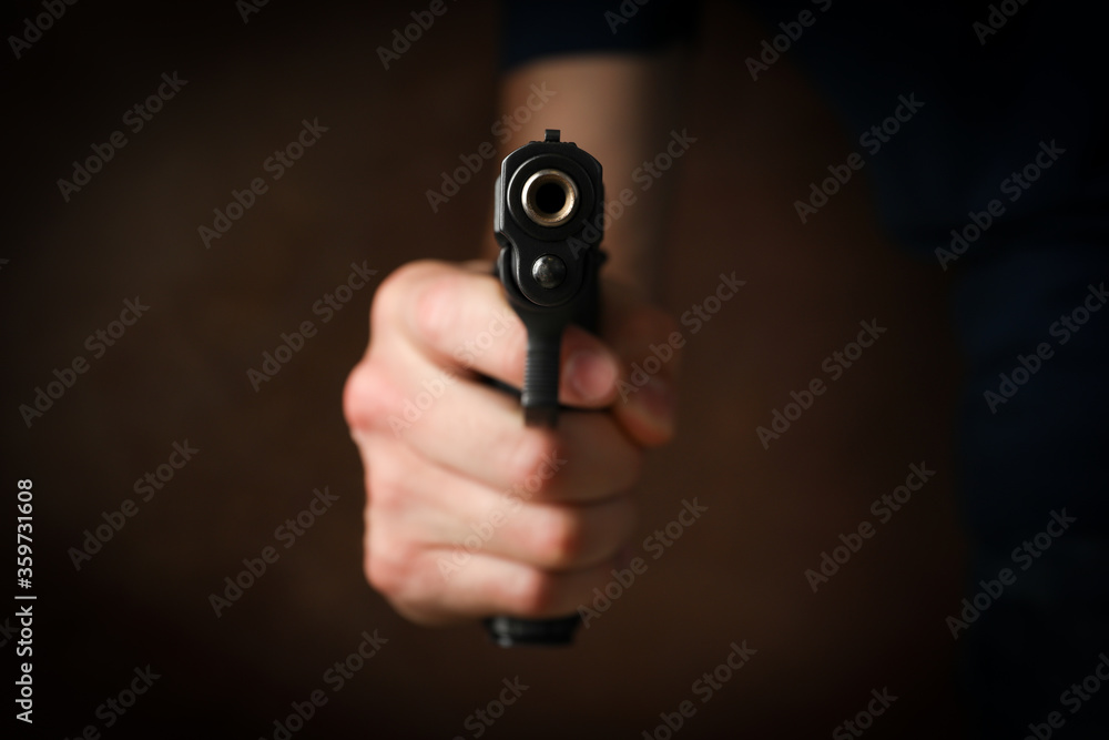 Man hold pistol. Selective focus. Robber. Violence Man hold pistol. Selective focus. Robber. Violence