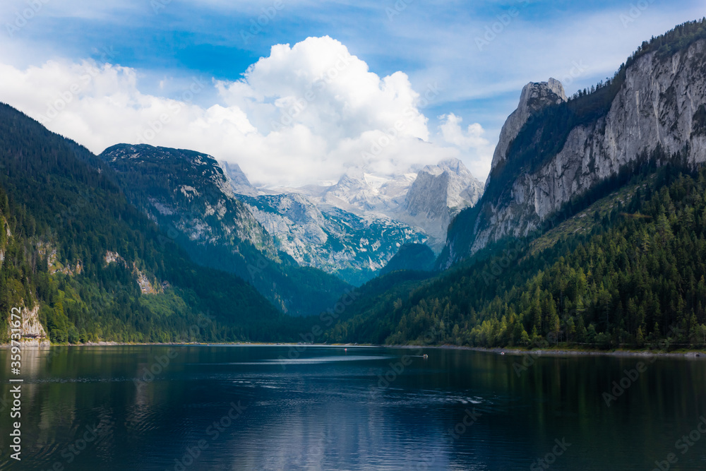 Spectacular mountain lake in a valley with the Dachstein mountain range and glacier in the background during summer