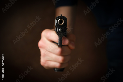Man hold pistol. Selective focus. Robber. Violence