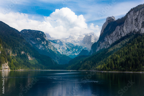 Spectacular mountain lake in a valley with the Dachstein mountain range and glacier in the background during summer