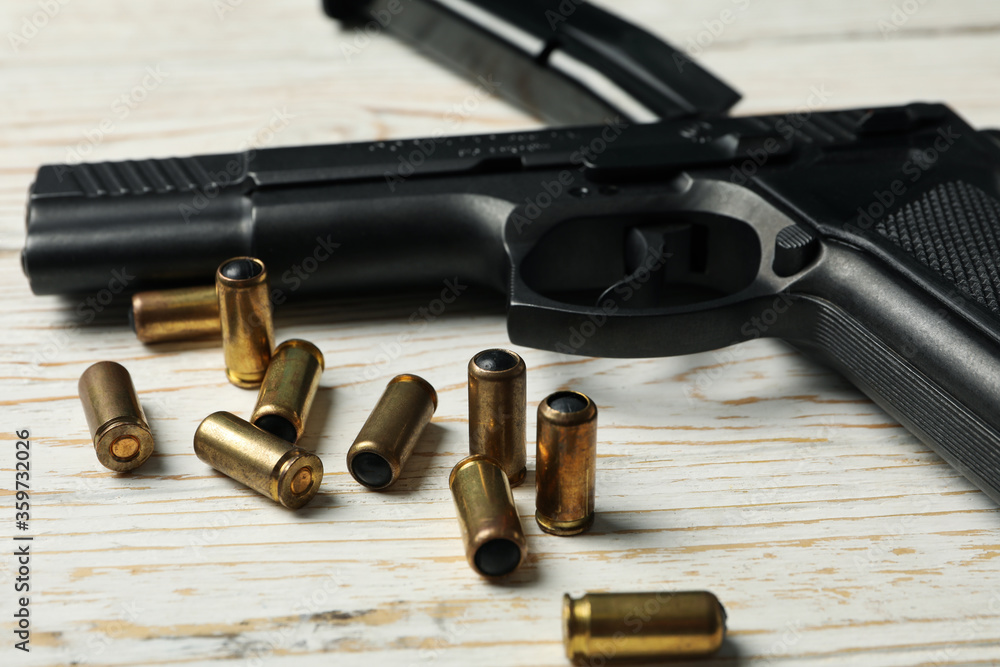 Pistol, bullets and magazine on wooden background Pistol, bullets and magazine on wooden background
