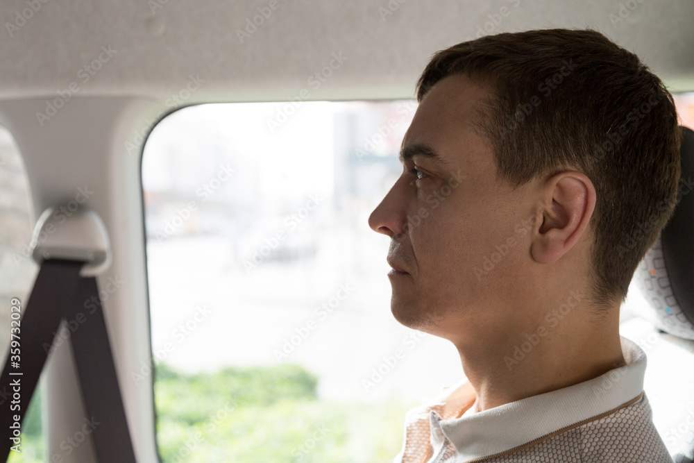 Fototapeta premium Passenger public transport in Europe. A 30-35 year old man sits in a taxi near the window.