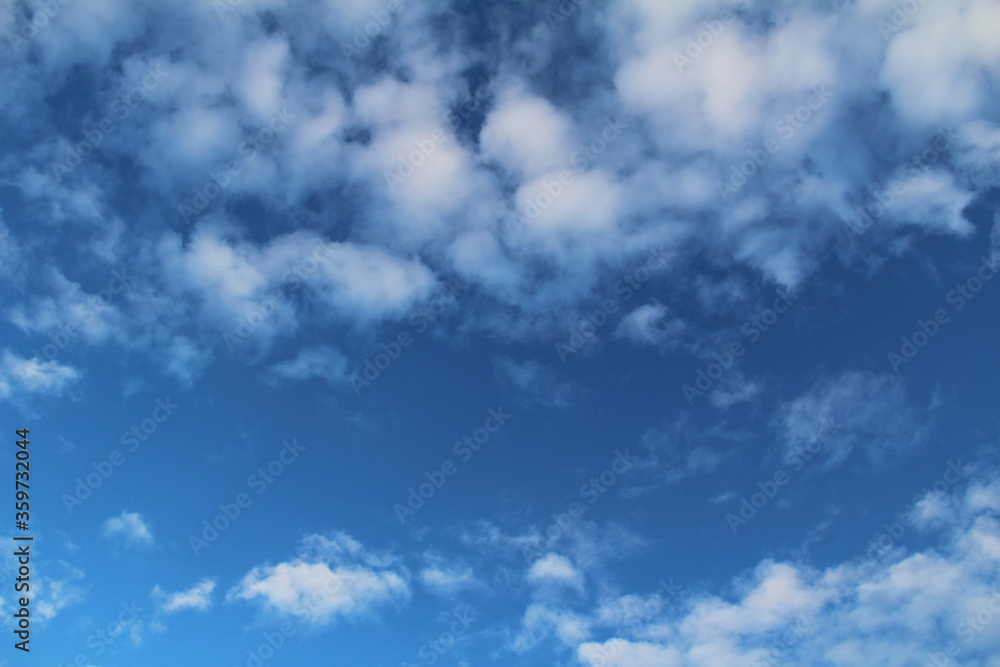 White clouds and blue sky as background. Photo of sky in sunny day. Nature background.