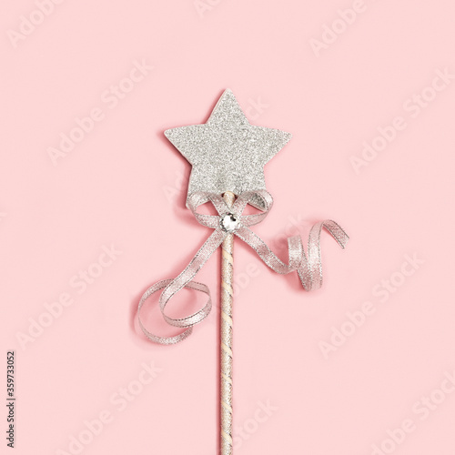Festive decoration, bright silver star with sequins on soft pink background with copy space. Minimal holiday concept. Flat lay. photo
