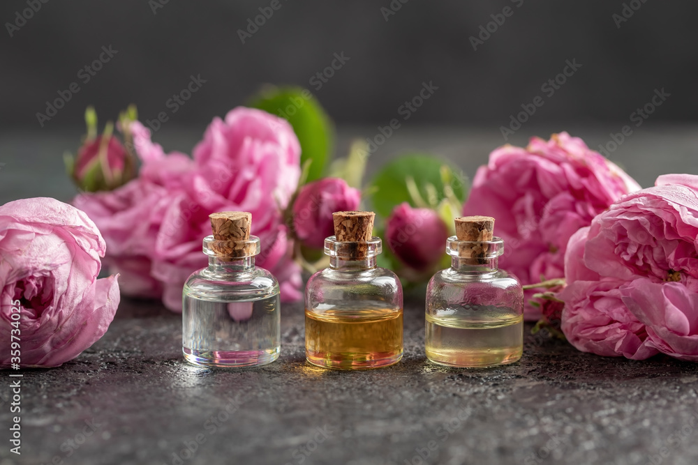 Three bottles of essential oil with cabbage rose flowers Three bottles of essential oil with cabbage rose flowers