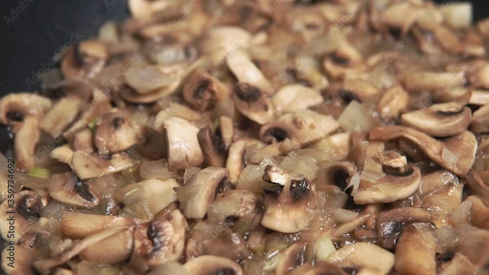 Roasting mushrooms in a frying pan. Sliced Champignons cooking Roasting mushrooms in a frying pan. Sliced Champignons cooking