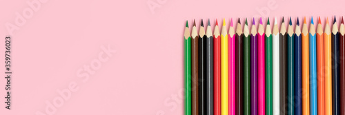Banner with row of colorful pencils on a beige background. Back to school concept with place for text.