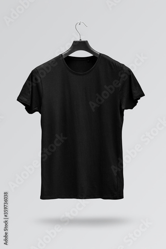 Front side of male black cotton t-shirt on a hanger isolated on white background. T-shirt without print