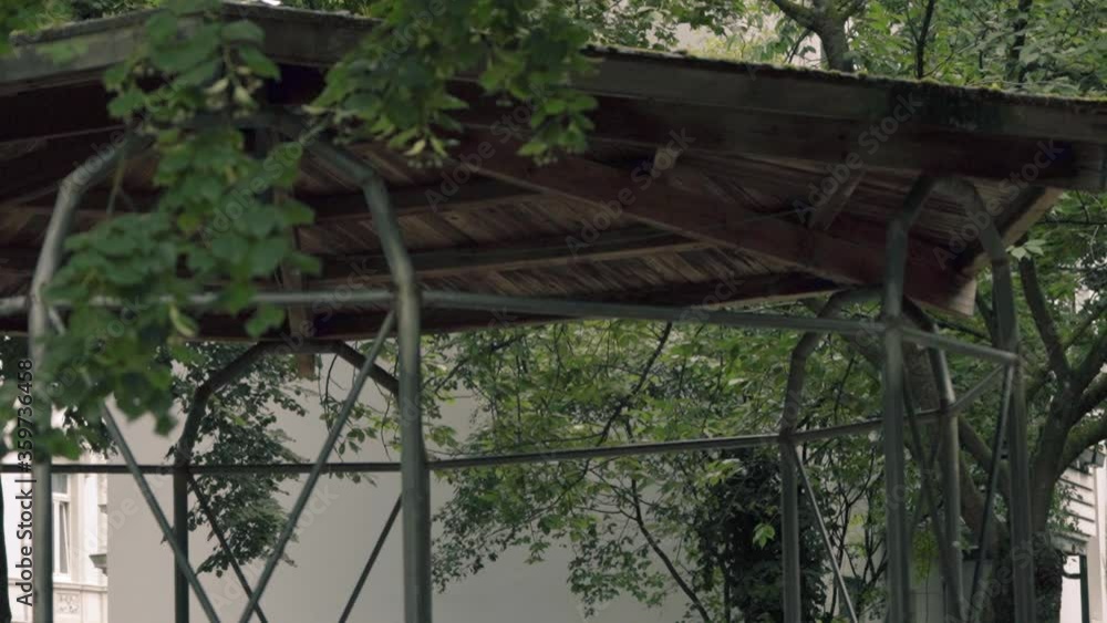 Worn-down gazebo hidden behind leaves Worn-down gazebo hidden behind leaves