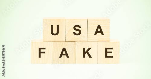 words USA fake made with small wooden blocks on light green