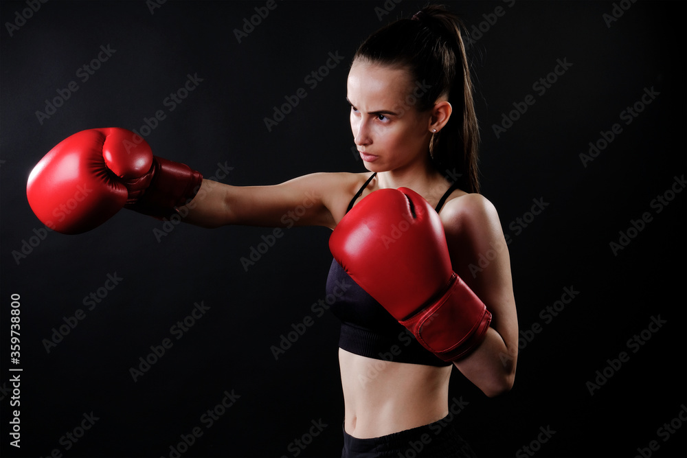 Beautiful girl in boxing gloves on a dark background Beautiful girl in boxing gloves on a dark background
