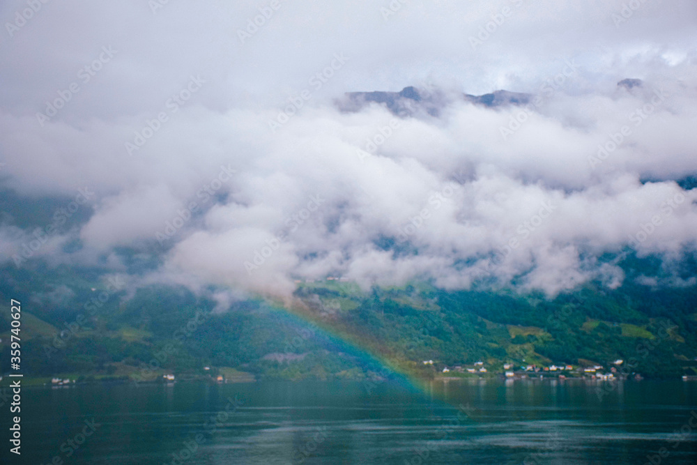 Rainbow in the water surrounded by mountains