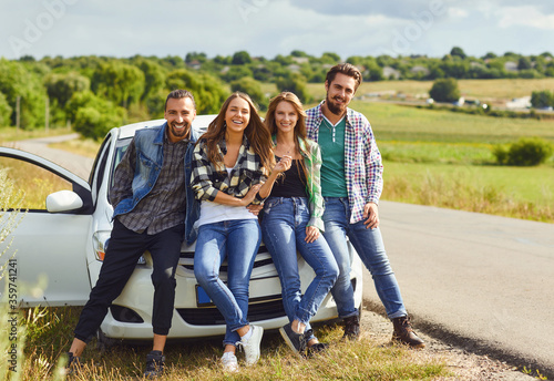 Group of people standing next travel in the car on road.