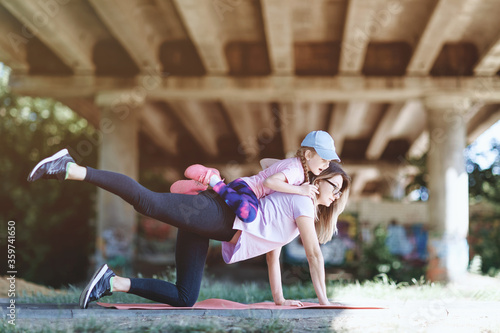 Mom and daughter on morning exercises in the park. Healthy lifestyle concept