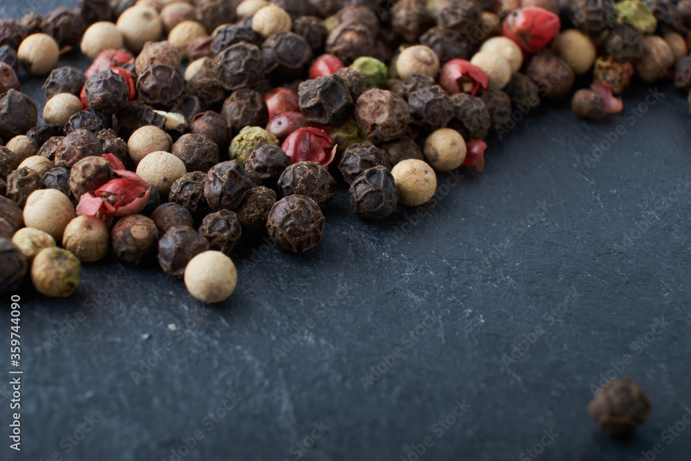 A mixture of peppers. Black, white, red polka dots. Isolated on a stone background. The selected sharpness A mixture of peppers. Black, white, red polka dots. Isolated on a stone background. The selected sharpness