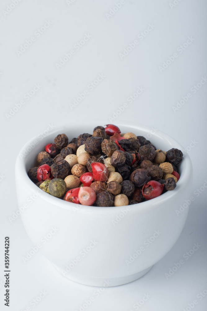 A mixture of peppers. Black, white, red polka dots. Isolated on a white background. The selected sharpness A mixture of peppers. Black, white, red polka dots. Isolated on a white background. The selected sharpness