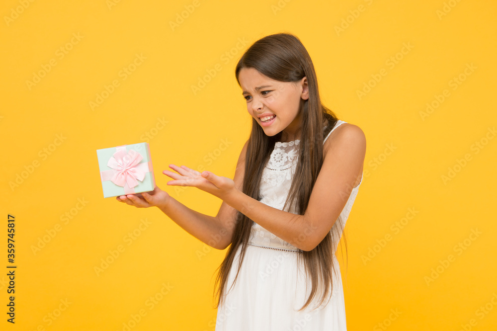 What is it. Unhappy child. Stop consumerism. Conscious purchase. Shopping concept. Portrait girl. Birthday gift. Child hold gift box. Kid girl gift. Shopping and discount. Irritated expression What is it. Unhappy child. Stop consumerism. Conscious purchase. Shopping concept. Portrait girl. Birthday gift. Child hold gift box. Kid girl gift. Shopping and discount. Irritated expression