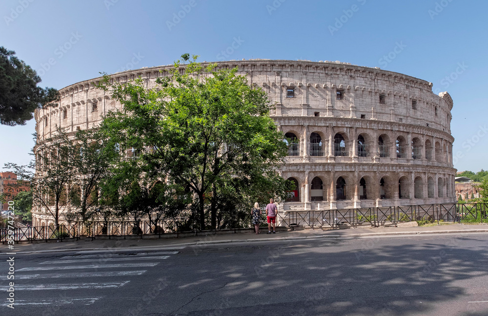 Rome Italy, tourists looking the Colosseum ancient amphitheater under clear blue sky