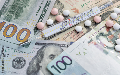 Healthcare cost concept. US dollars with pills. Multi-colored pills, thermometer, medicines. The high cost of drugs and healthcare. US dollar, Belarusian rubles. Medicine