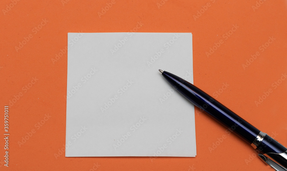 Abstract orange background and white paper with a ballpoint pen, place for text. Abstract orange background and white paper with a ballpoint pen, place for text.