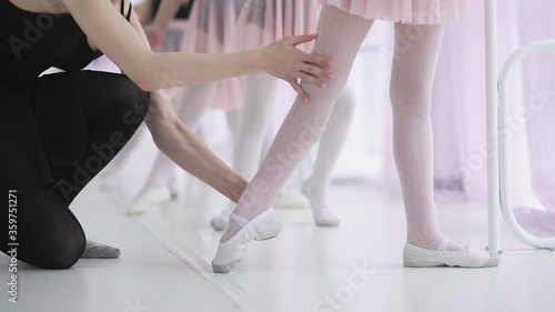 Wallpaper Mural Close up feet of unrecognizable little girls in white socks and ballet shoes, their ballet teacher correcting them Torontodigital.ca