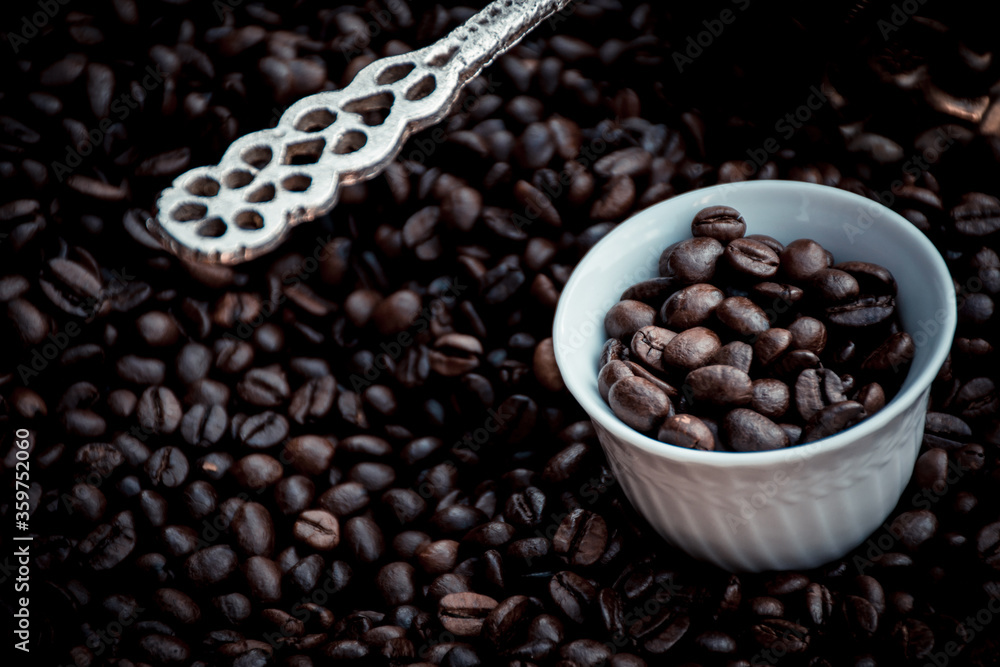 coffee pot and cup filled and surrounded by coffee beans coffee pot and cup filled and surrounded by coffee beans