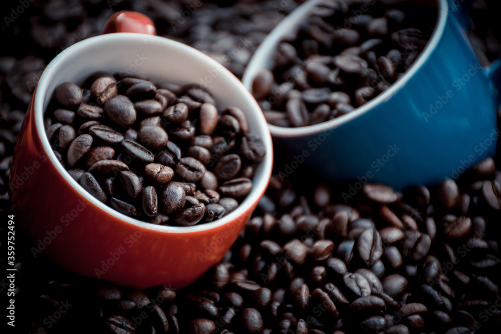 red and blue coffee cups filled and surrounded by coffee beans red and blue coffee cups filled and surrounded by coffee beans