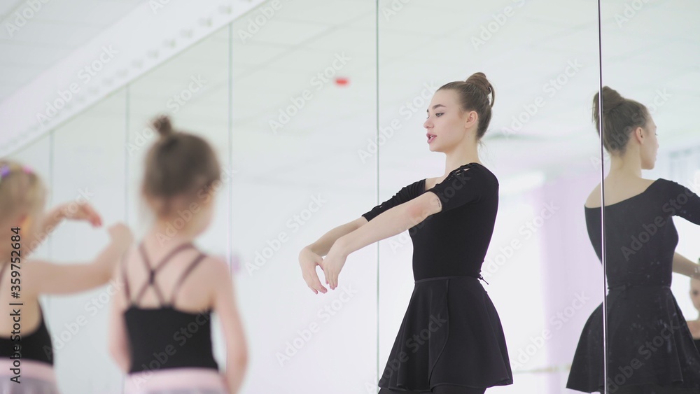 Cute Female ballet teacher is teaching a lesson to little girls Cute Female ballet teacher is teaching a lesson to little girls
