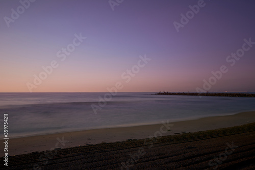 Sunrise on the beach  jetty with fishermen