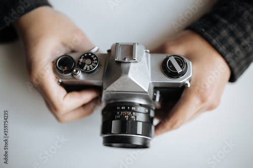 Vintage Pentax film camera in the hands of a man on a white background