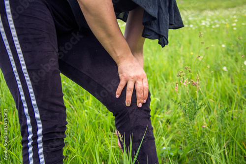 sport woman with leg hurts in a park in summer © Vahagn