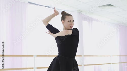 Young ballerina makes beautiful movements with her hands.