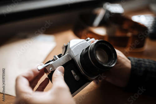 Vintage Pentax film camera in the hands of a man on a white background.