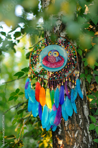 Closeup vibrant dreamcatcher with colorful feathers in park
