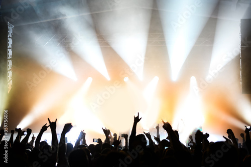dancing and applauding crowd in front of the stage at a music festival. atmosphere of a concert set of musicians. show poster
