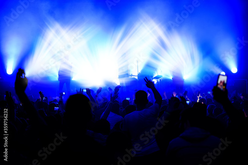 blurred view of the stage in the light of spotlights from the crowd at a concert. funny dances at a music festival. show poster