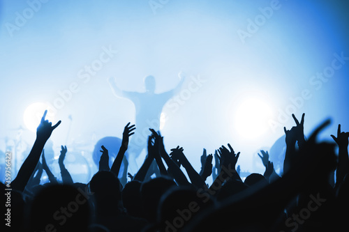 Blurred silhouettes of rock band musicians with beautiful lighting on stage and crowds at a concert. atmosphere of a music festival. light spotlights