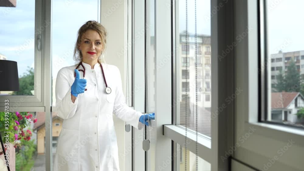 Smiling female doctor gesturing thumb up. Pretty woman doctor showing thumb up sign Smiling female doctor gesturing thumb up. Pretty woman doctor showing thumb up sign