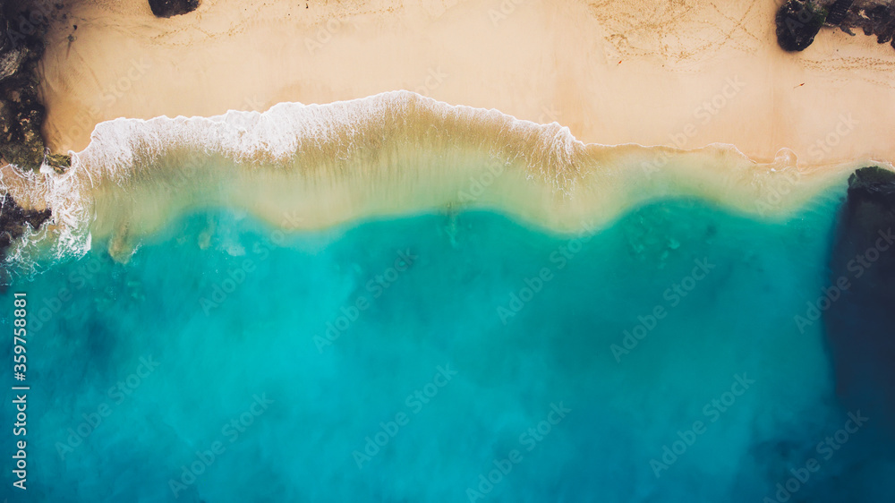 Top view aerial photo from flying drone of beauty nature landscape with paradise beach and Indian Ocean in summer day in Bali. Amazing seascape with small waves. Perfect background for travel website