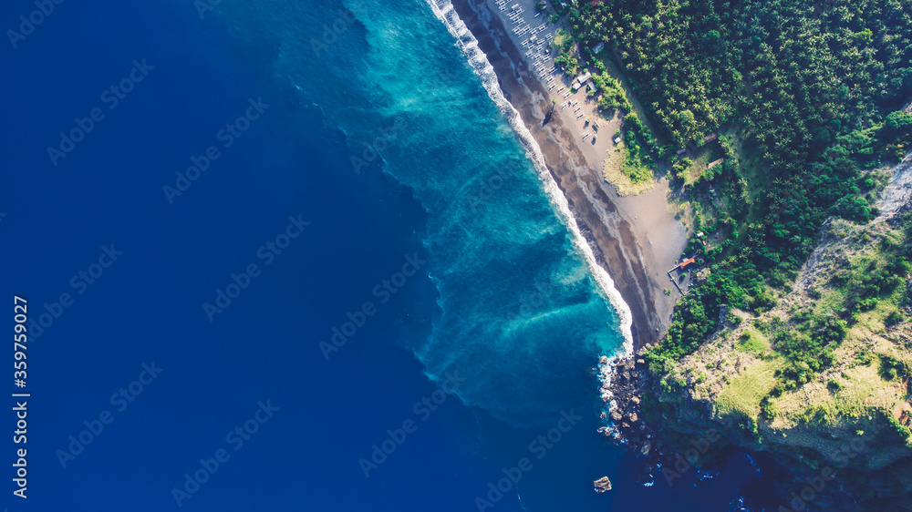 Aerial top view photo from flying drone of a paradise beach with tropical plants and blue calm sea with copy space for your advertising text message or promotional content. Beautiful nature wallpaper