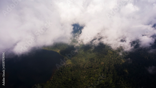 Aerial photo from airplane cockpit of a white, partly clouds over Asian island and sea with copy space for your advertising text. Beautiful nature with perfect background for your travel web site