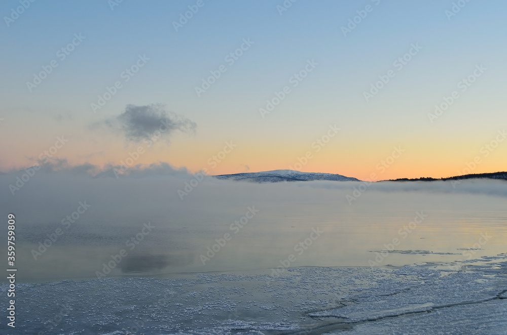 pink sunset sky in winter over frozen fjord and dense ice fog pink sunset sky in winter over frozen fjord and dense ice fog