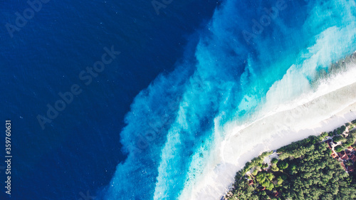 Top view aerial drone photo of one of the most beautiful beaches in the world, incredibly beautiful blue water makes a fascinating picture while ocean current carries the white sand seabed. Background