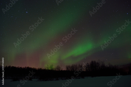 beautiful aurora borealis over arctic circle landscape in winter