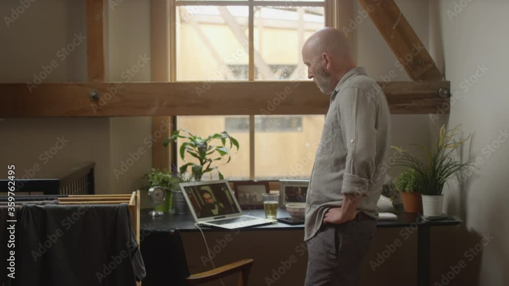 Wide shot of a man having a video chat work meeting while working from home during quarantine Wide shot of a man having a video chat work meeting while working from home during quarantine