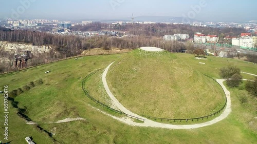 Krakus Mound in Krakow, Poland. The origin of the mound, probably early medieval kurgan, is not known. Old quarry in front. City panorama in the background. Aerial 4K video. photo