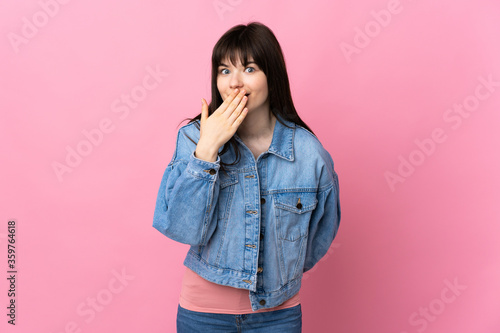 Young Ukrainian woman isolated on pink background happy and smiling covering mouth with hand