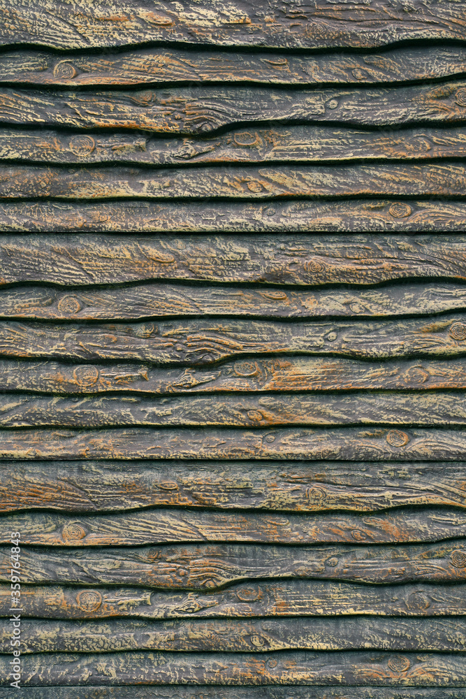 fence of unedged boards, which are stylishly painted in brown and gold tones. texture of the old wood